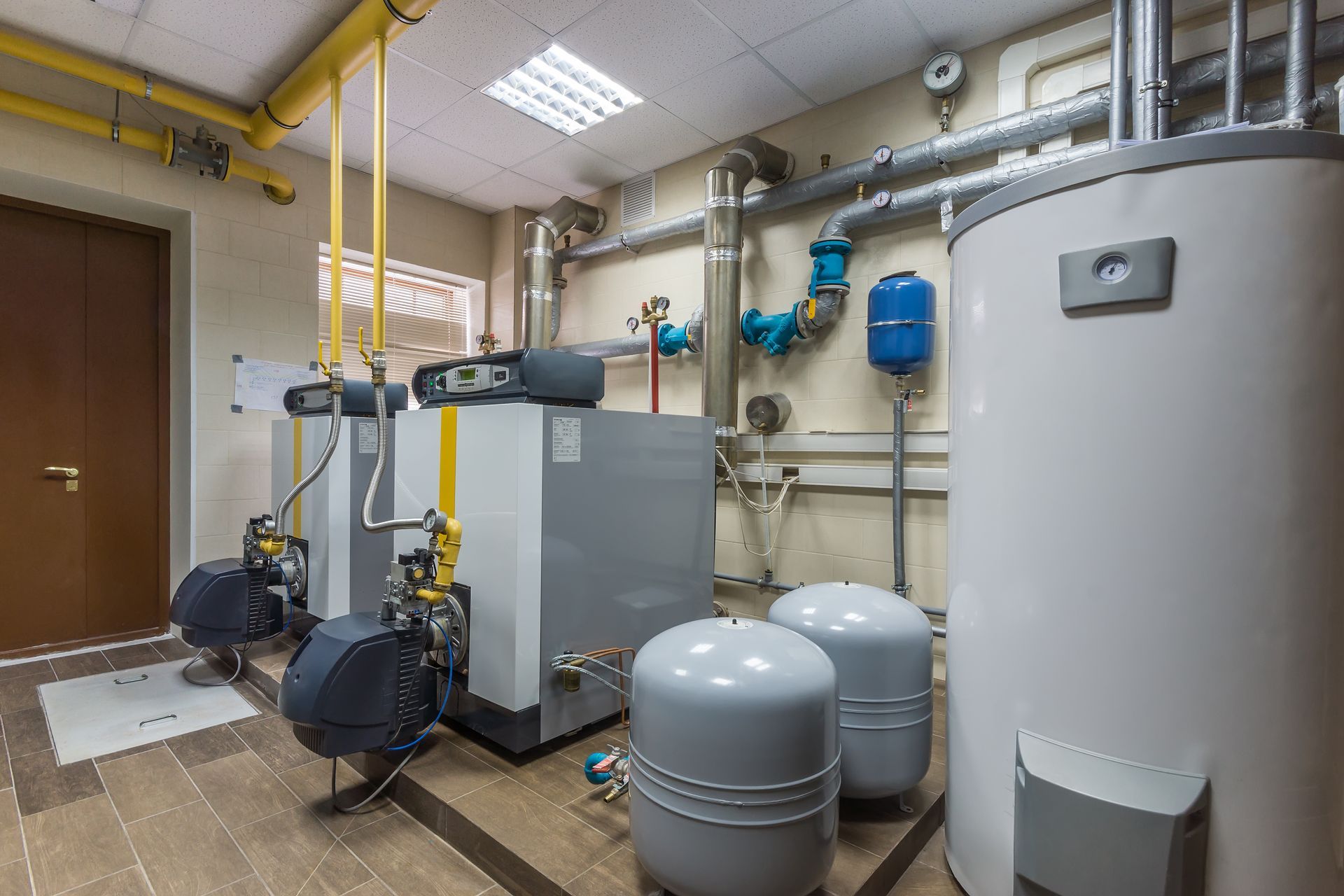 A room with a lot of boilers and tanks in it.