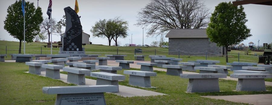 A cemetery with a lot of benches and a statue in the background.