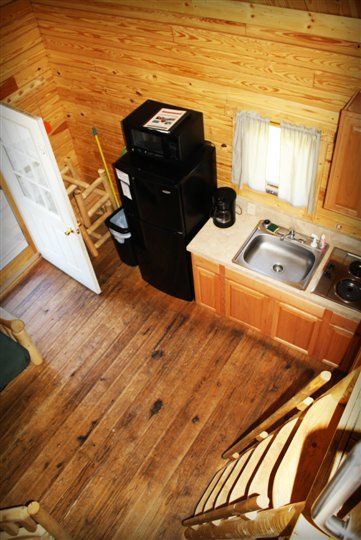 A wooden cabin with a table and chairs and a flat screen tv.