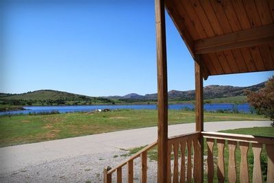 A porch with a view of a lake and mountains.