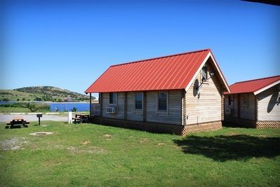 A small house with a red roof and a picnic table in front of it