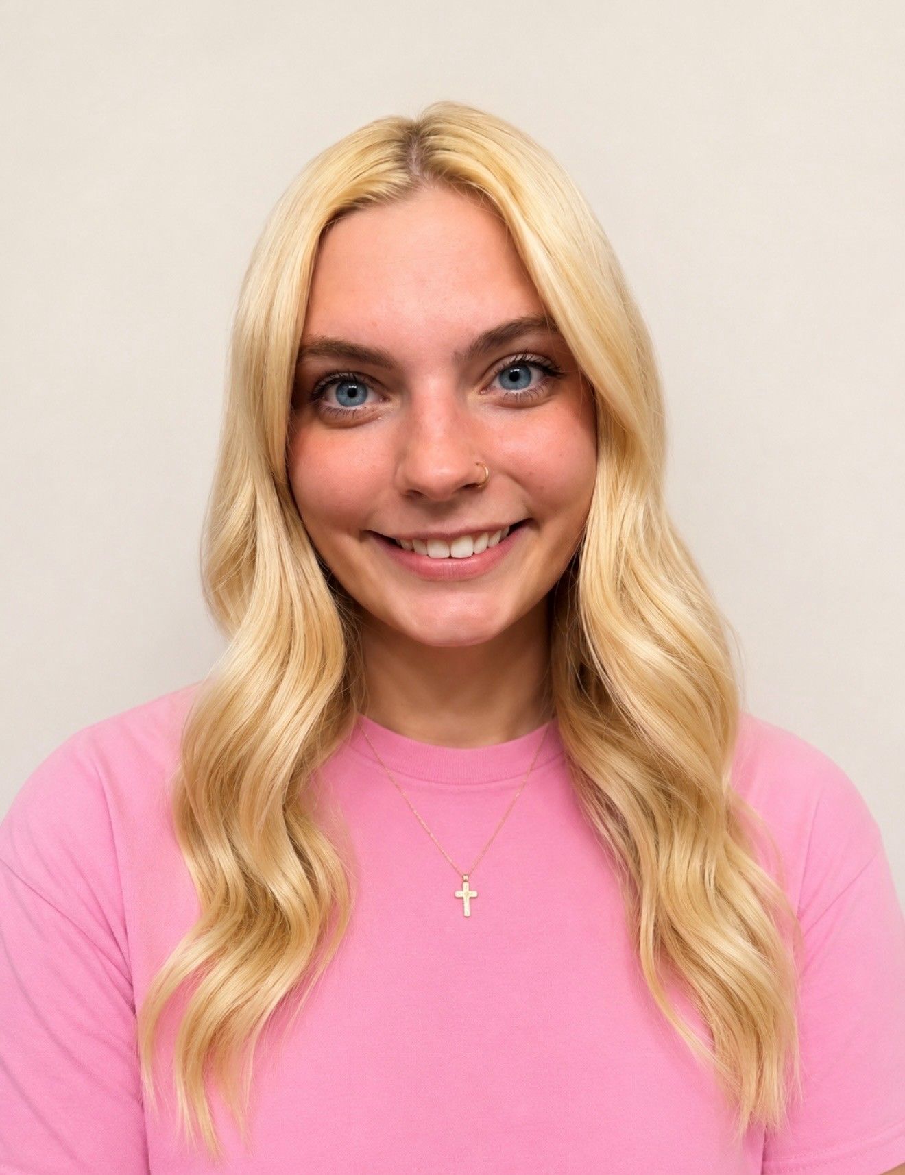 A woman in a pink sweater is smiling for the camera.