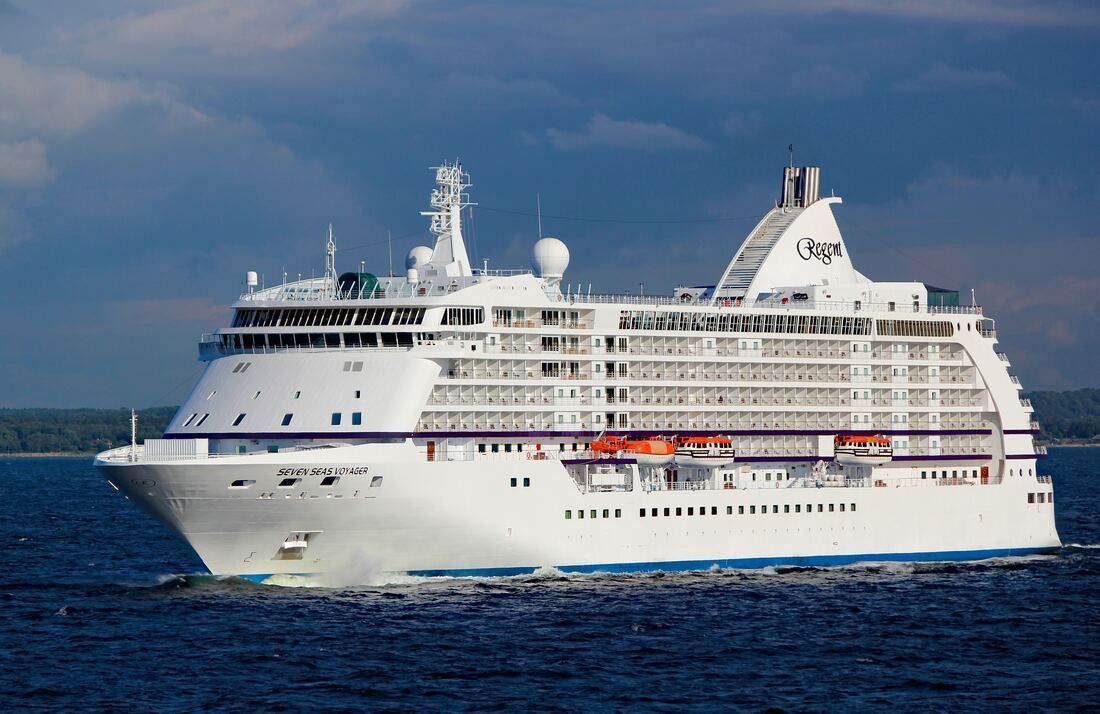 A large white cruise ship is floating on top of a body of water.