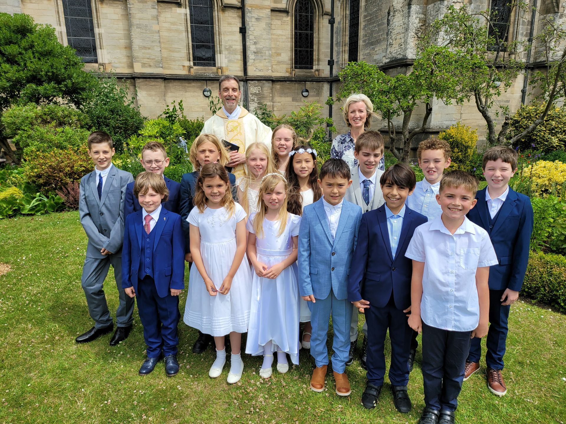 A group of children in smart dress smile at the camera