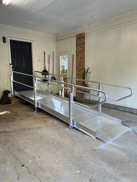 A handicap ramp is in a garage next to a door.