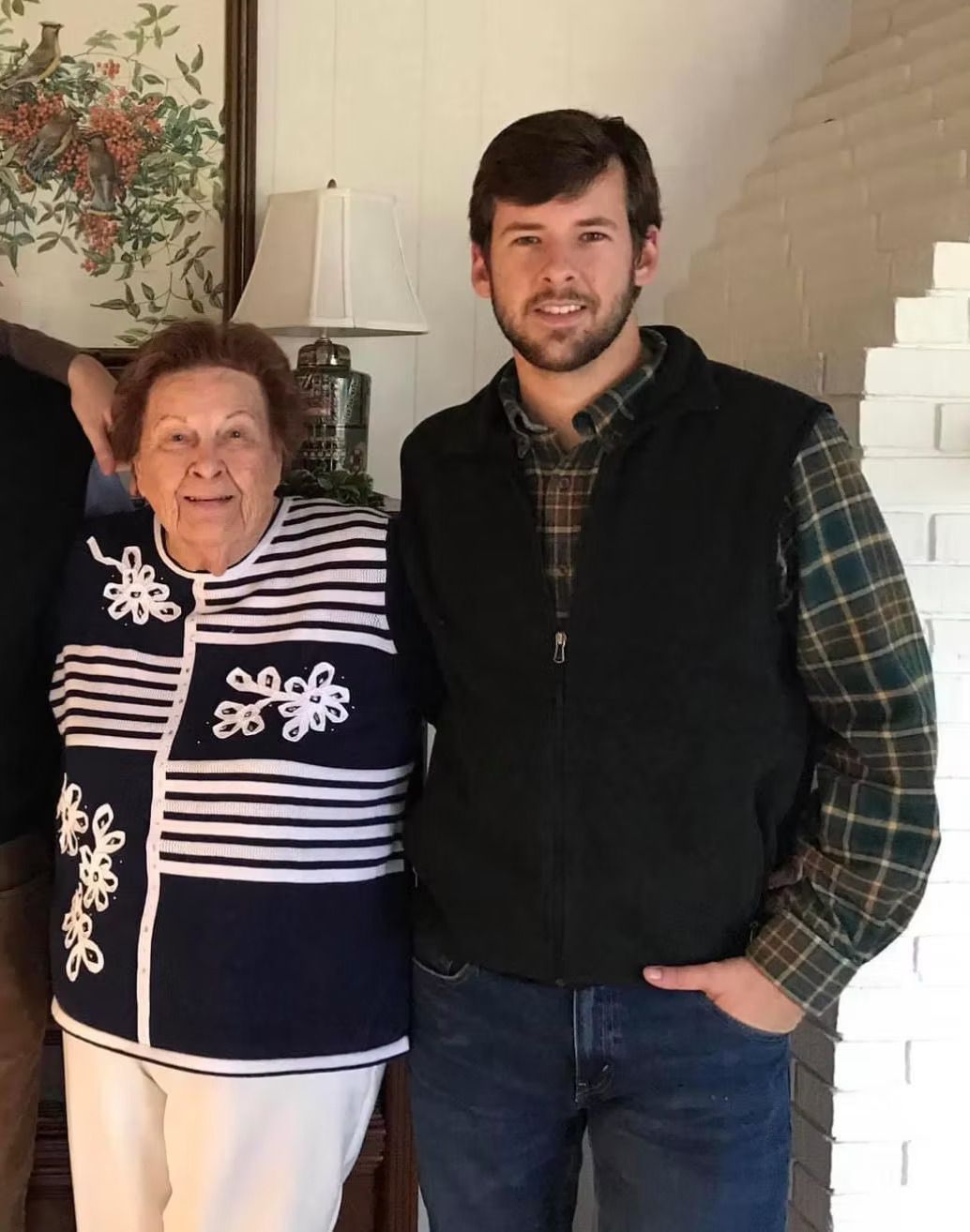 A man and a woman are posing for a picture in a living room.