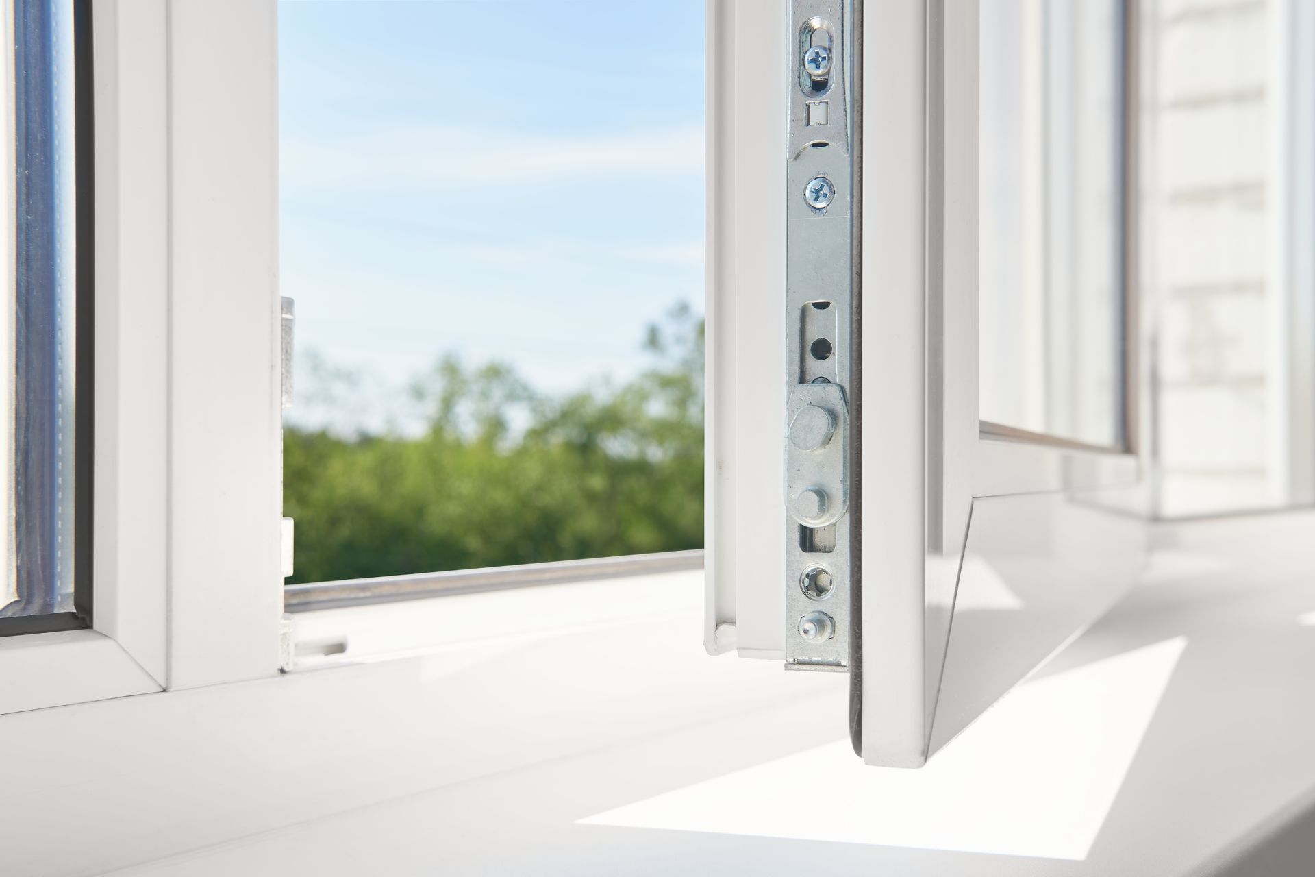 An elderly woman is holding onto a stainless steel hand rail in a bathroom.