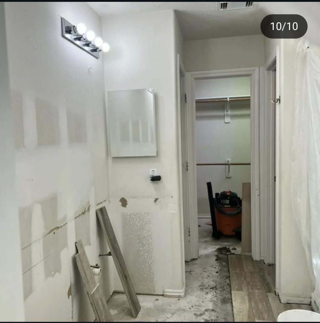 A bathroom with a vacuum cleaner on the floor