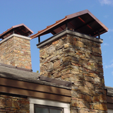 Michigan Wildlife Solutions - Two chimneys on top of a building with a blue sky in the background