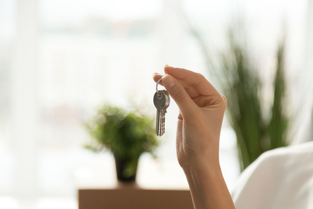 A Hand Holding a Single Silver Key — Richardson Conveyancing In Tumbi Umbi, NSW