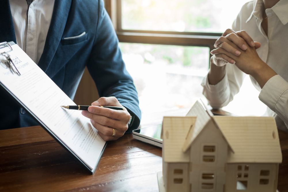 A Person in a Suit Points to a Document While Sitting Across — Richardson Conveyancing In Mudgee, NSW