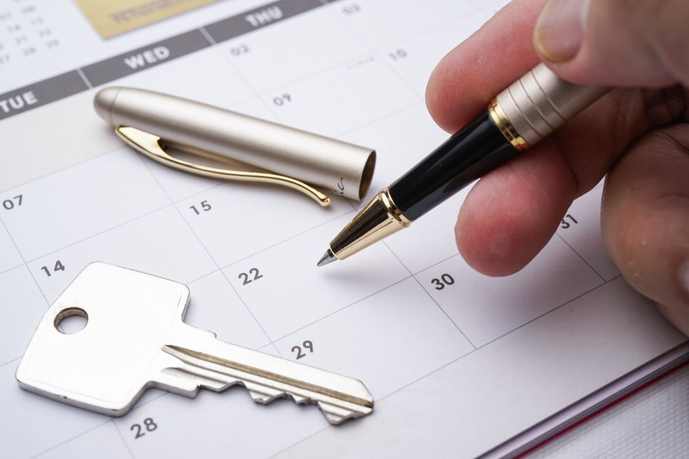 A Hand Holds a Pen Over a Calendar Date — Richardson Conveyancing In Sydney, NSW