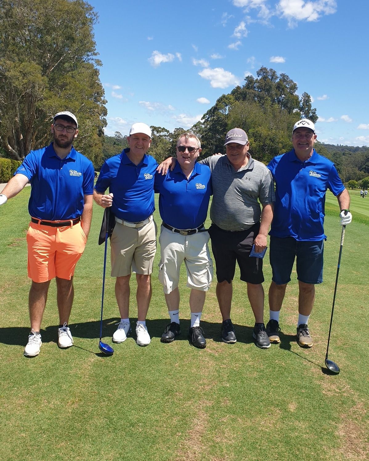 A group of men are posing for a picture on a golf course.