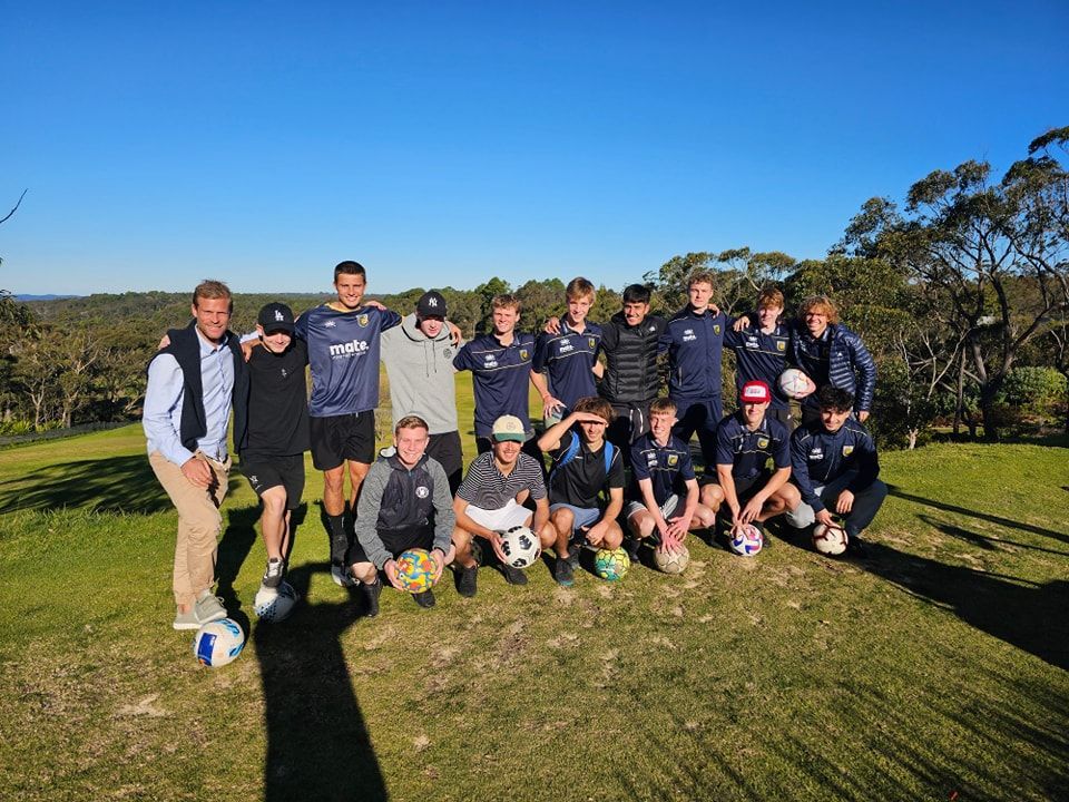 A group of young men are posing for a picture with footgolf balls.