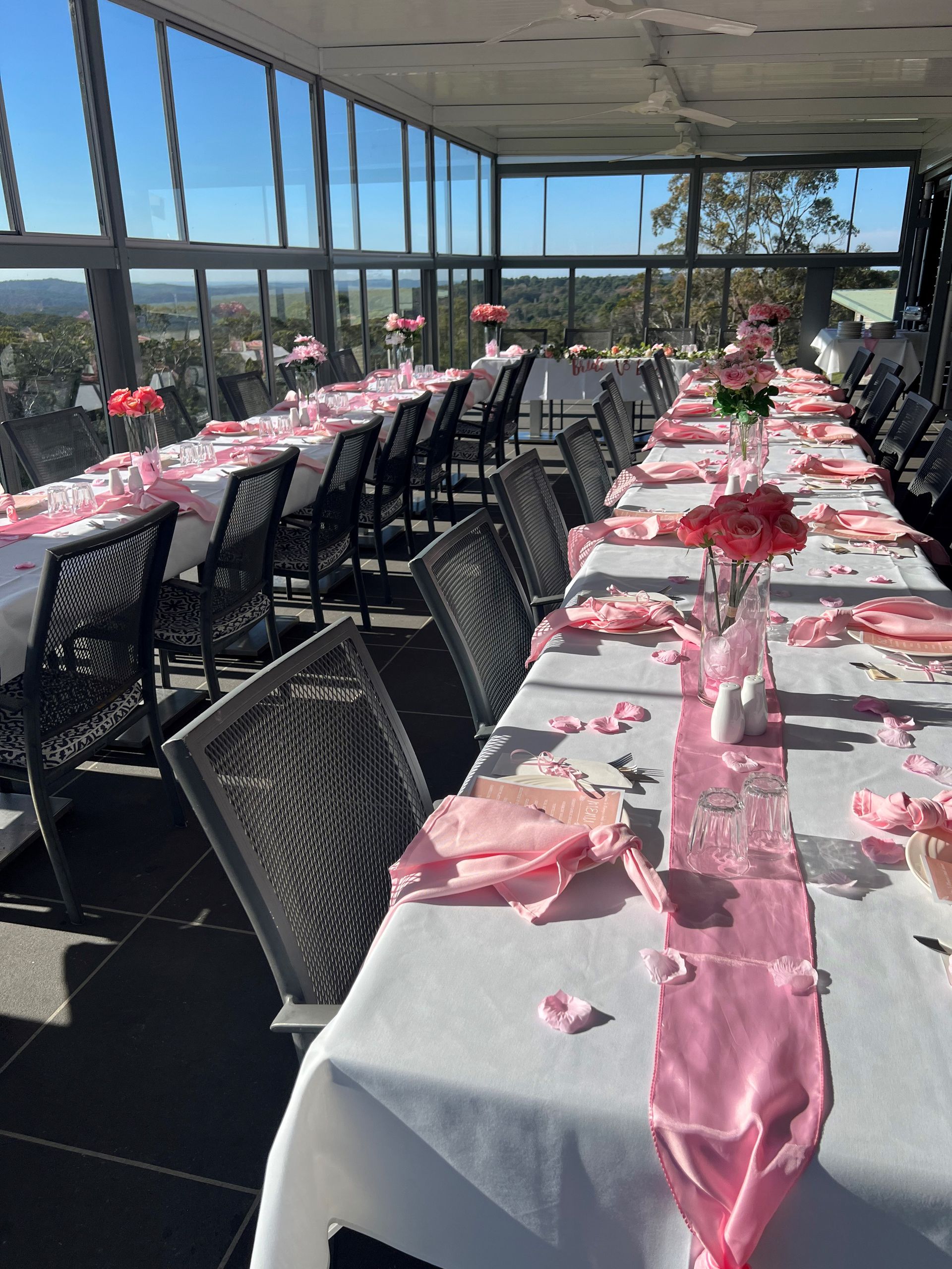 A large room with tables and chairs and a view of a golf course.