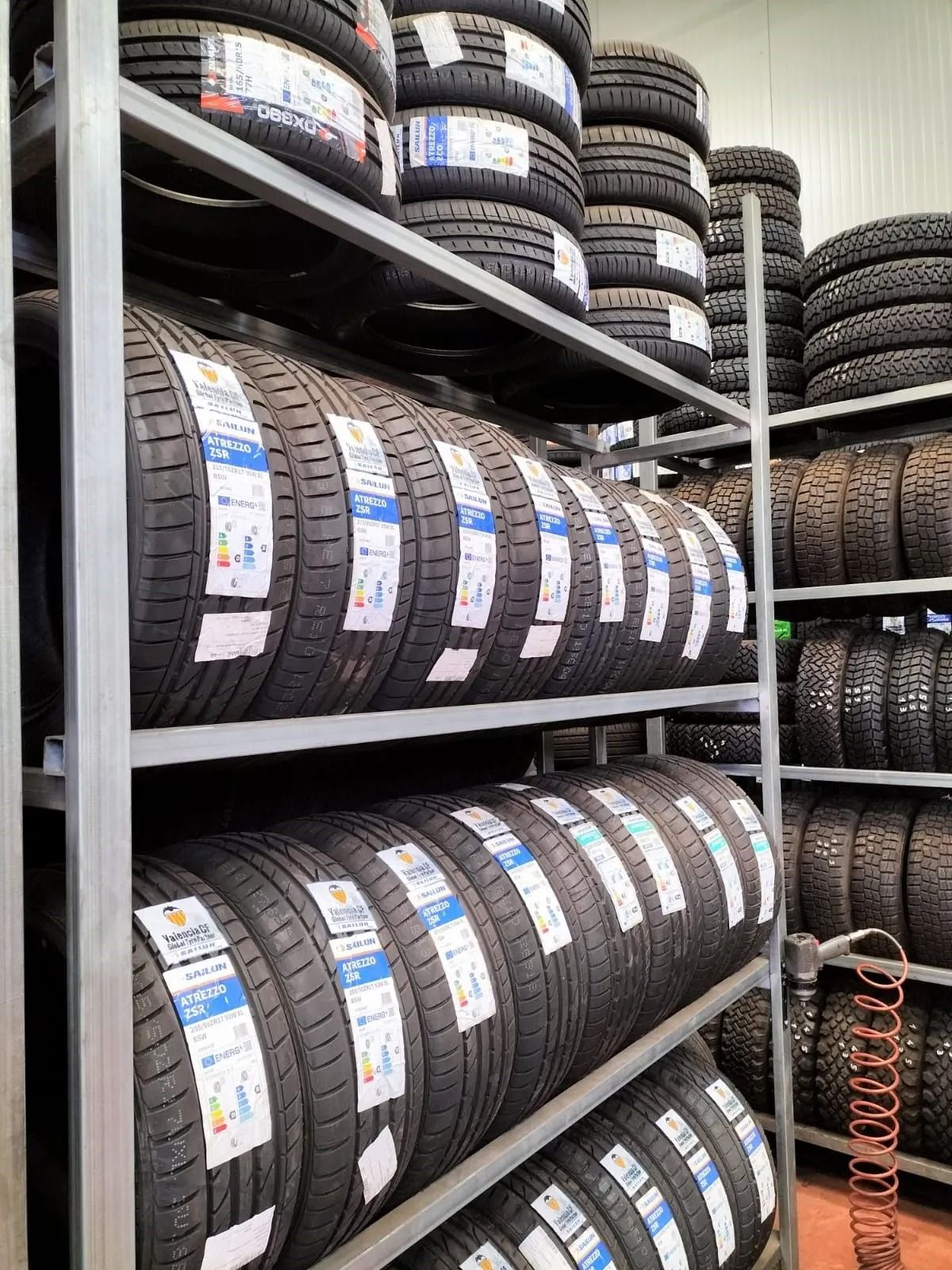 Pneumatici accatastati su scaffali metallici in un magazzino.