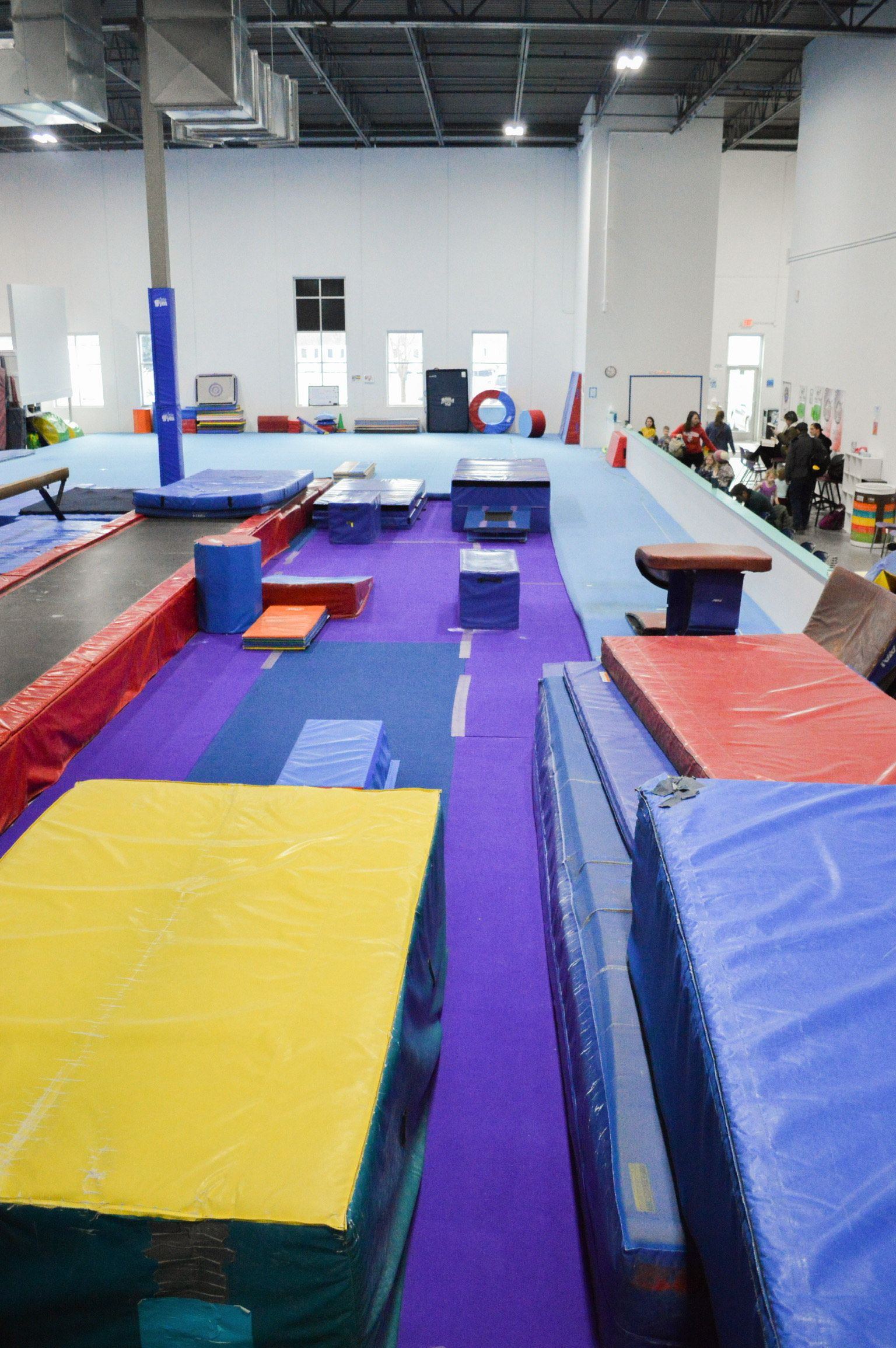 A gym with a lot of mats and a purple carpet.