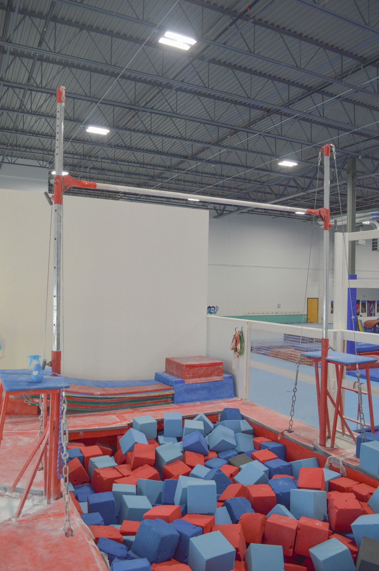 A foam pit filled with red and blue cubes in a gym.