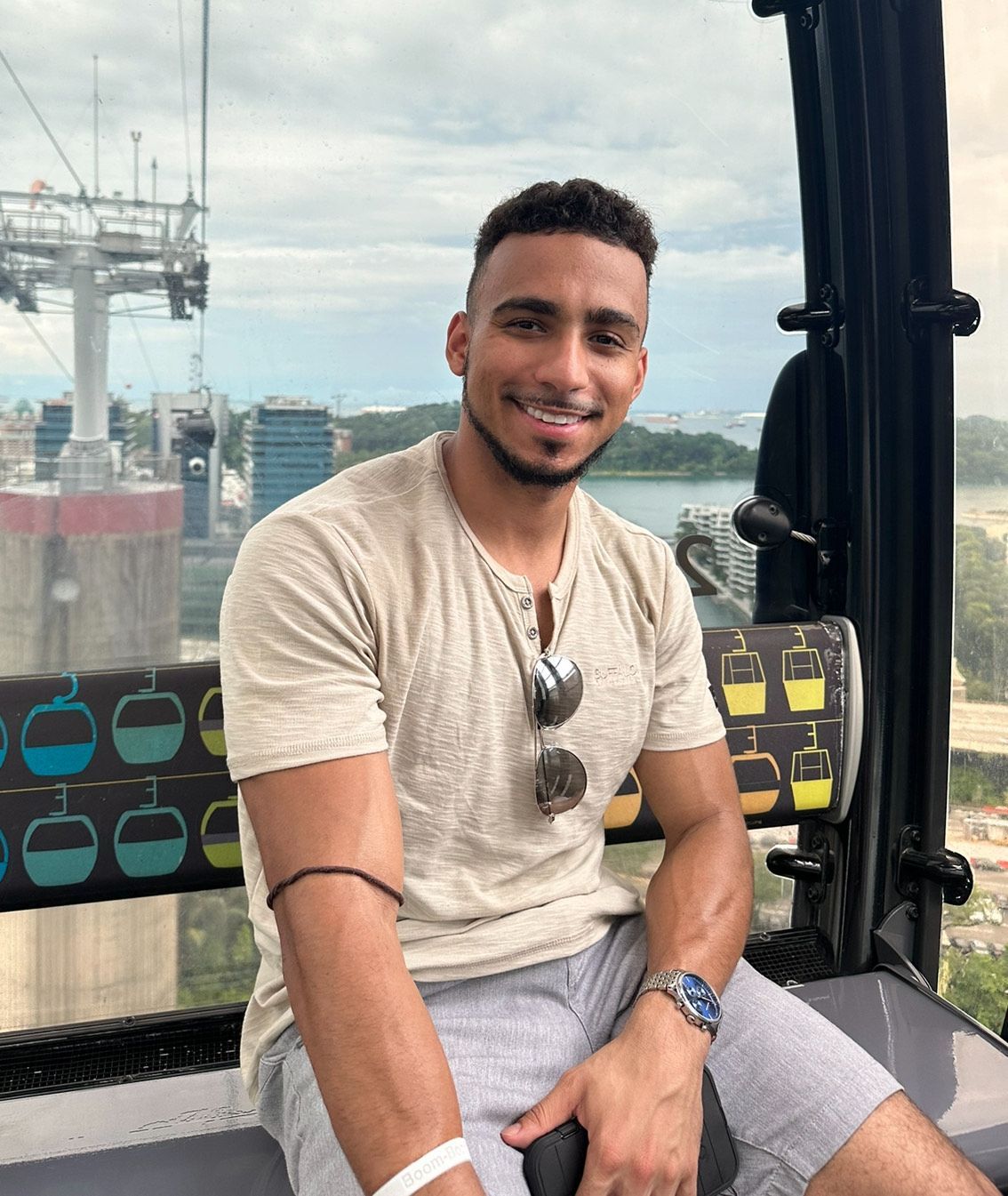 A man is sitting on a ferris wheel and smiling.