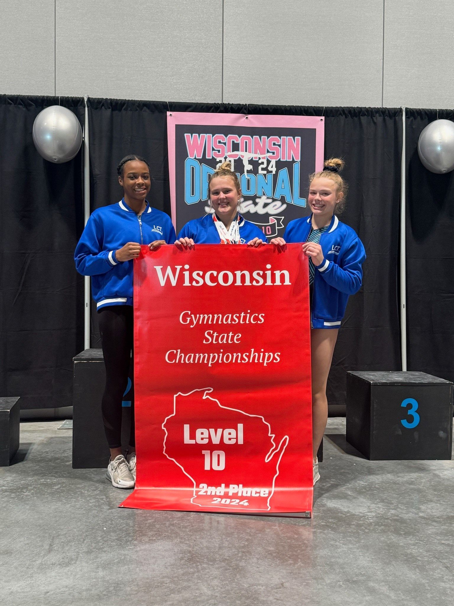 A group of girls are holding a sign that says wisconsin level 10.