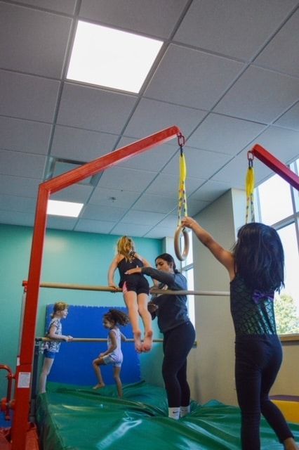 A group of young girls are doing gymnastics in a gym