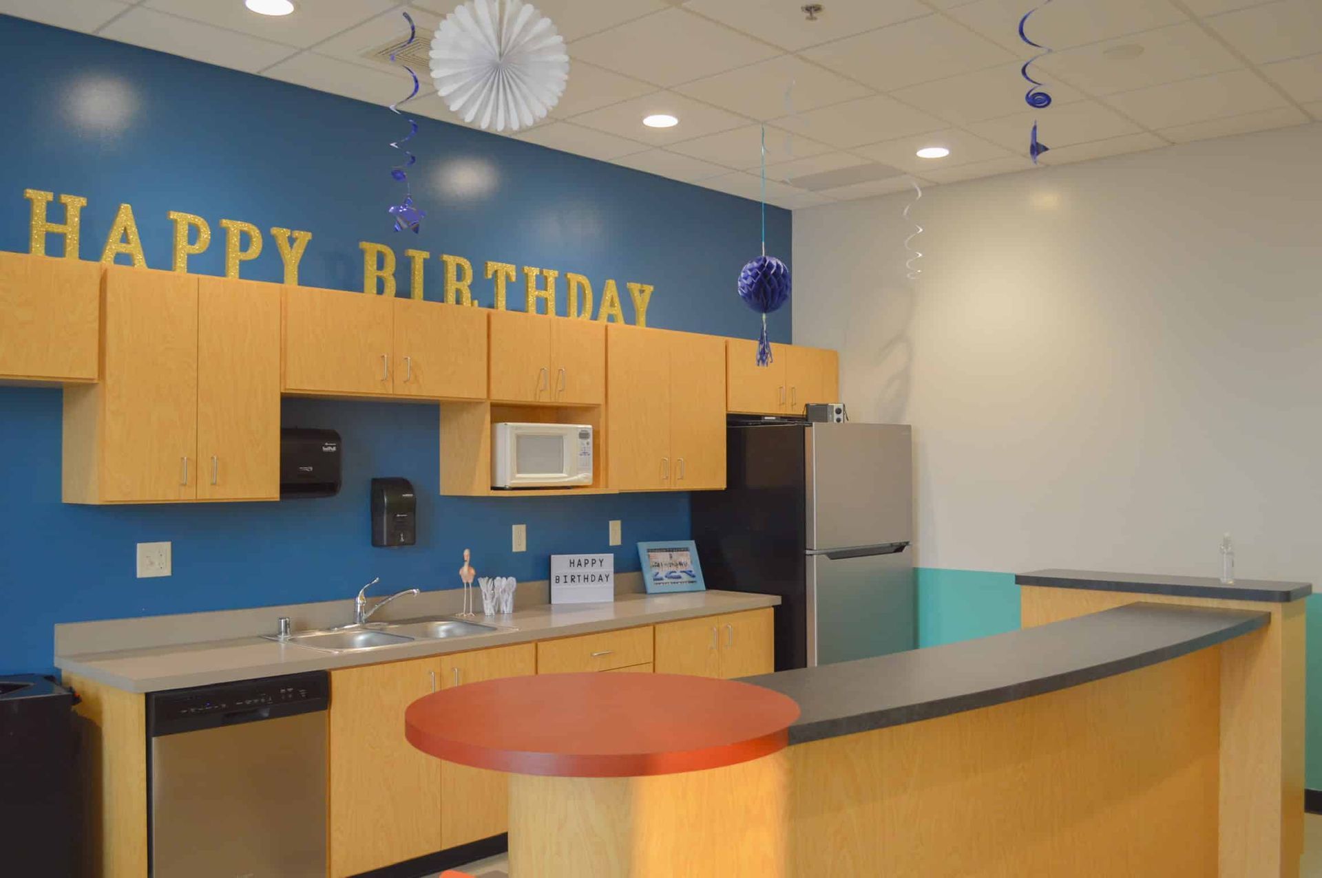 A kitchen with a sign on the wall that says `` happy birthday ''.