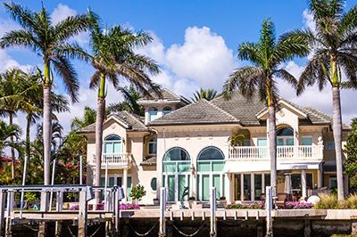 A large white house with palm trees in front of it