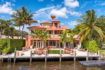 A large house is sitting next to a body of water.