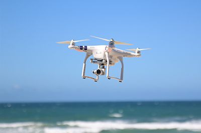 A drone is flying over the ocean.