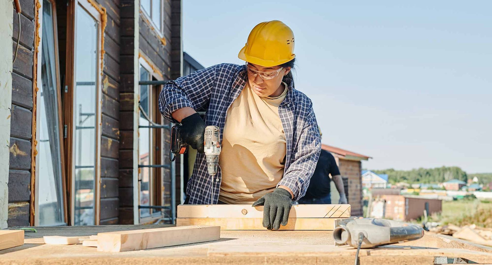 A man is using a drill to drill a hole in a piece of wood.
