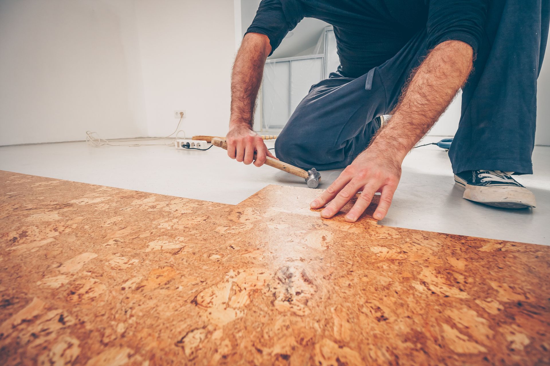 Worker Picks and Installs Series of Cork Flooring With a Hammer