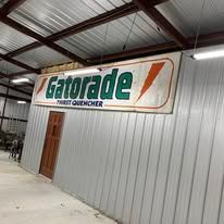 A gatorade sign is hanging from the ceiling of a building.