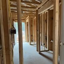 A hallway in a house under construction with wooden beams.