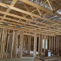 The inside of a house under construction with a lot of wooden beams.