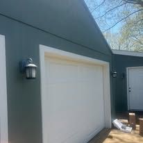 A garage door is being installed on the side of a house.