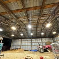 A large barn with a tractor inside of it.