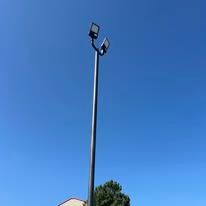 A tall pole with two lights on it against a blue sky.