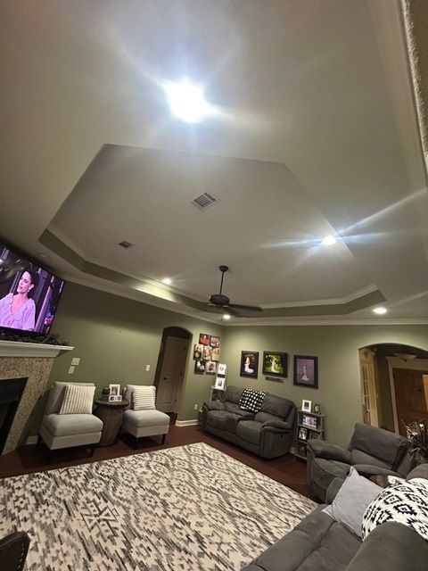 A living room with a couch , chairs , and a television.