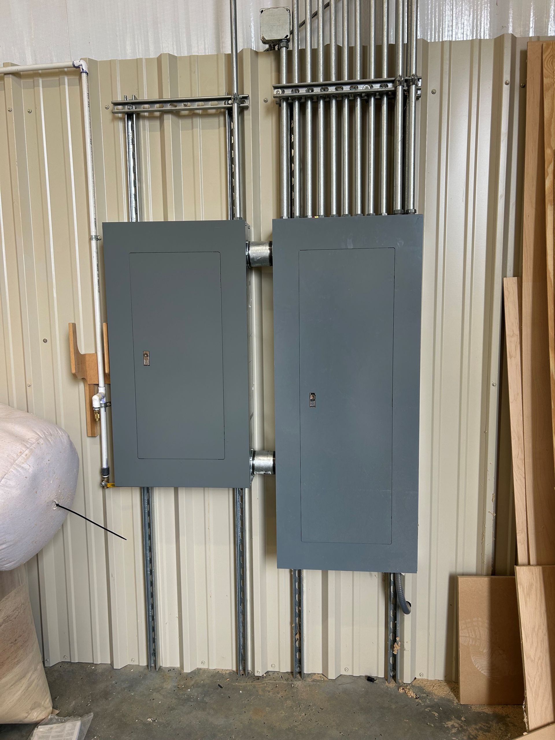 Two electrical panels are mounted to a metal wall