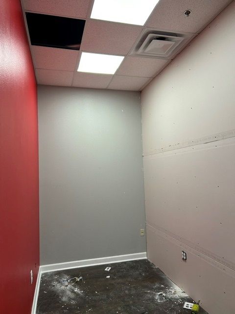 An empty room with a red wall and a white ceiling