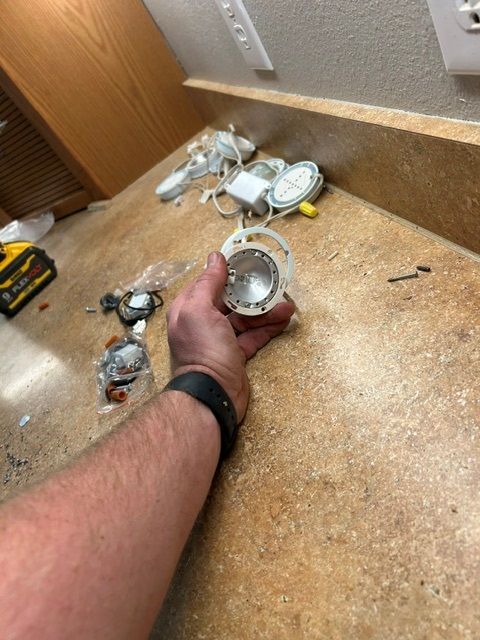 A person is holding a light bulb in their hand on a counter.