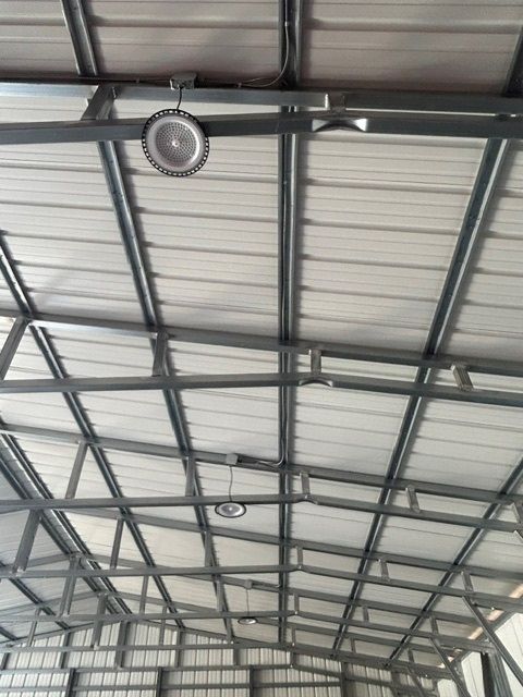 The ceiling of a building with a fan hanging from it.