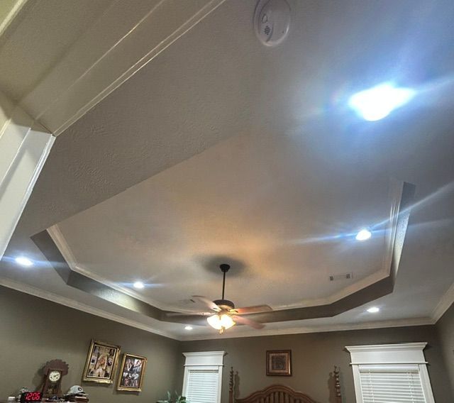 A bedroom with a ceiling fan and a clock on the wall