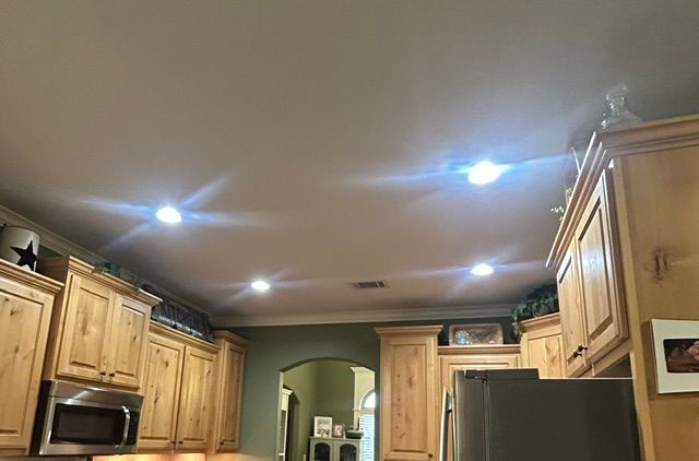 A kitchen with wooden cabinets , stainless steel appliances , and a refrigerator.