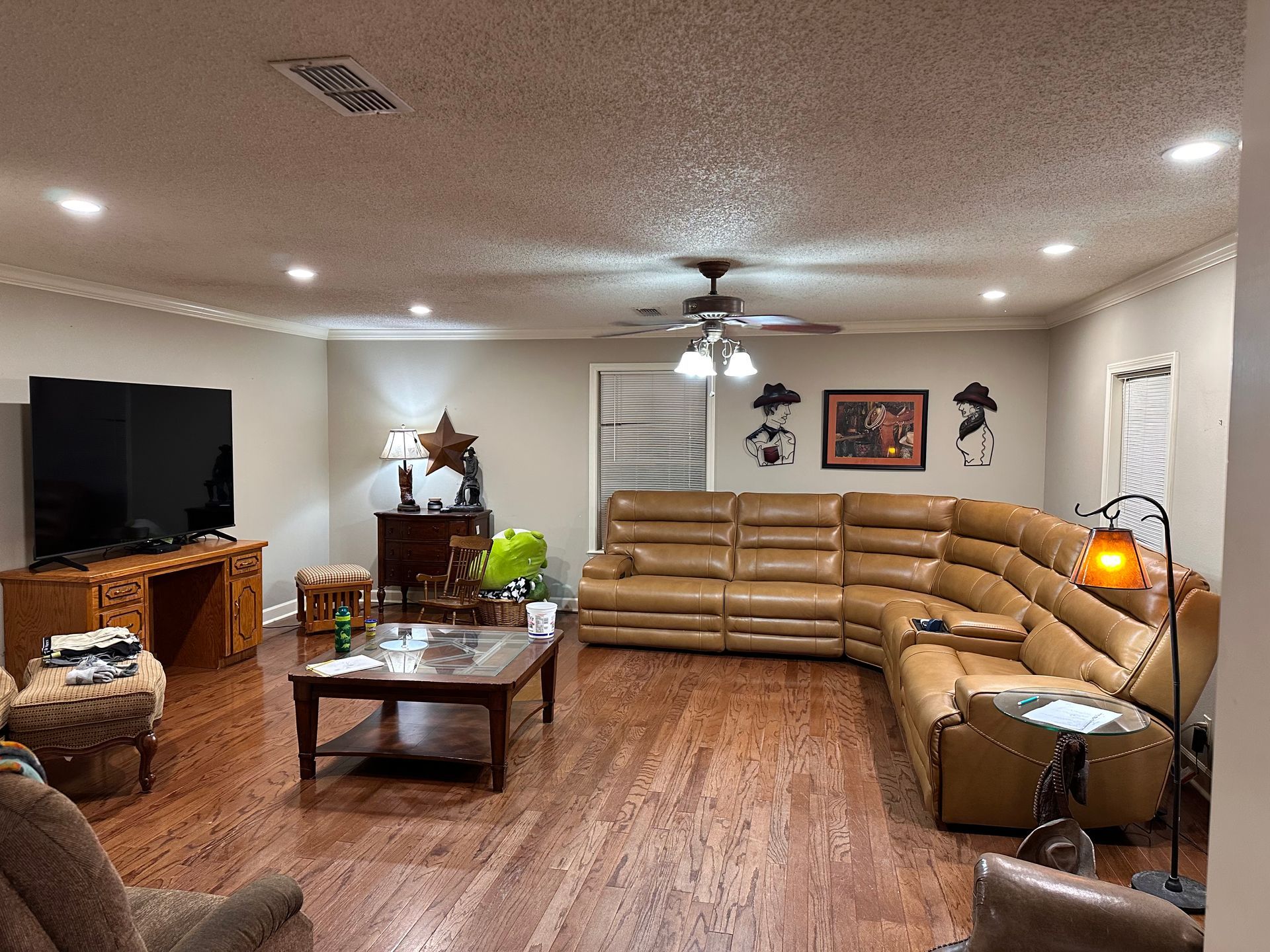 A living room with a large sectional couch and a flat screen tv.
