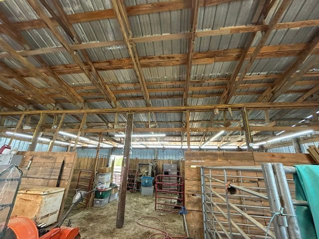 The inside of a barn with a roof made of metal and wood.