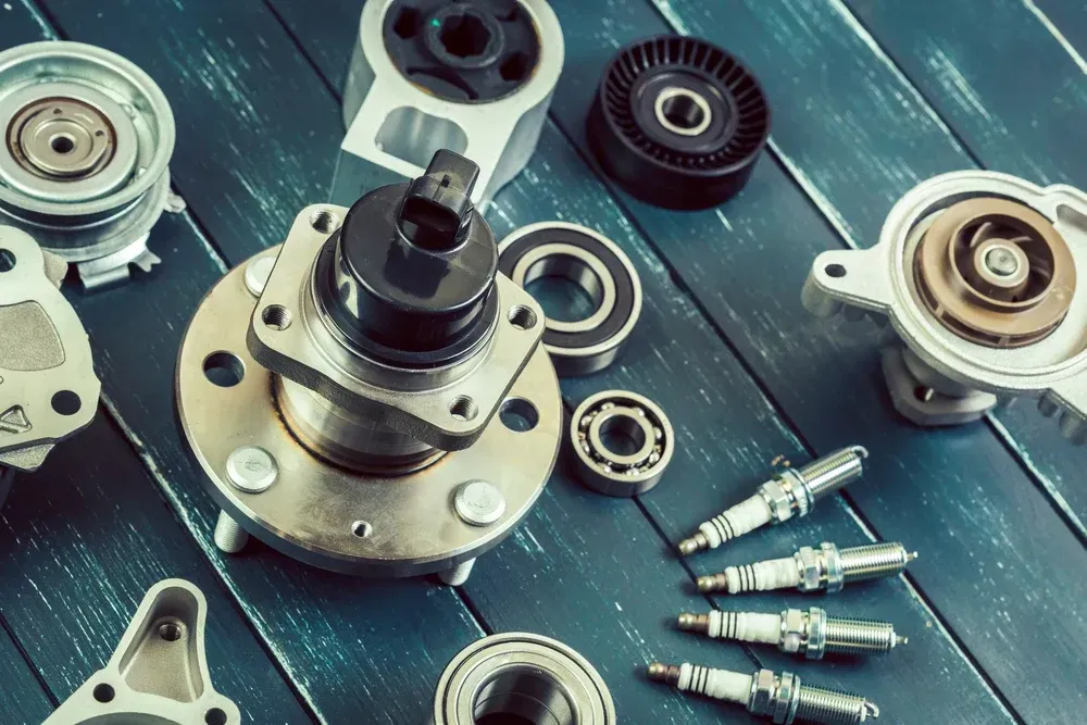 Various automotive parts including spark plugs, bearings, and pulleys arranged on a blue wooden surface. — Murwillumbah Motor Wreckers in South Murwillumbah, NSW