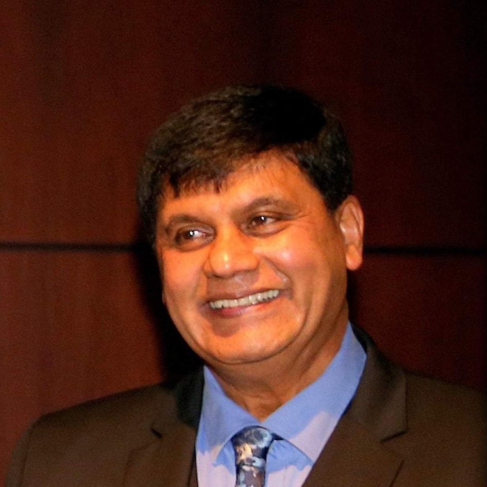A man in a suit and tie is smiling for the camera