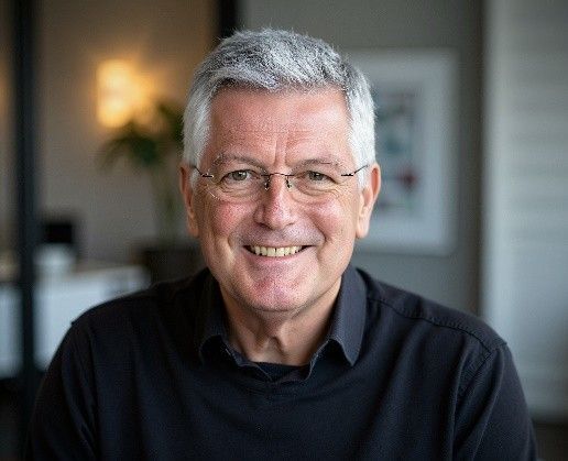 Richard Hill - A man wearing glasses and a black shirt is smiling for the camera.