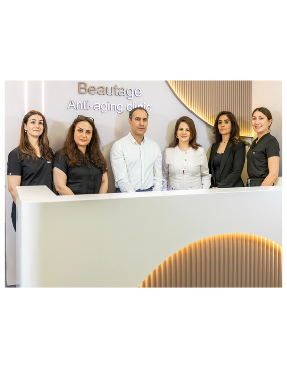 Clinic reception team standing behind a white front desk in a bright, modern lobby